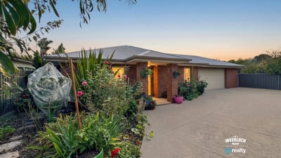 Beautifully landscaped exterior with vibrant garden, inviting entrance, and ample parking space for multiple vehicles.