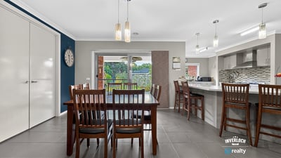 Modern kitchen and dining area with ample natural light and direct access to an outdoor space.