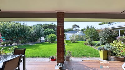 Spacious outdoor patio overlooking a vast, well-maintained garden ideal for entertaining and relaxation.