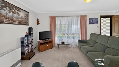 Spacious living room with large windows, offering ample natural light and a cozy atmosphere for gatherings.