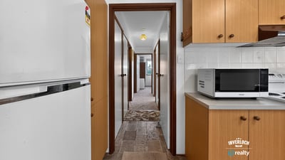 Spacious kitchen leads to ample hallway, offering convenient access to multiple rooms in this inviting home.