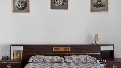 Cozy bedroom featuring vintage decor, modern furnishings, and ample natural light, perfect for relaxation.