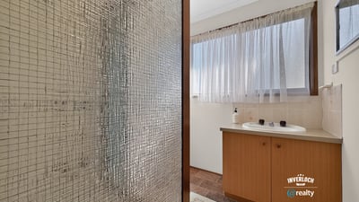 Bright bathroom featuring a spacious layout, large window for natural light, and practical design elements.
