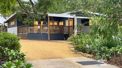 Bright, inviting home set on a spacious lot with a welcoming deck and lush landscaping.