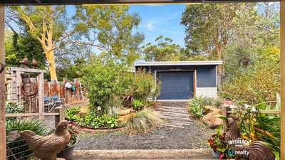 Enjoy a picturesque view of well-maintained gardens and a spacious shed from this outdoor area.