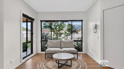 Bright and inviting living space featuring large windows that offer a view of the lush garden.