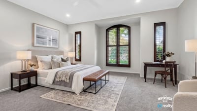 Spacious bedroom featuring large windows, plush carpet, and ample natural light for a cozy atmosphere.