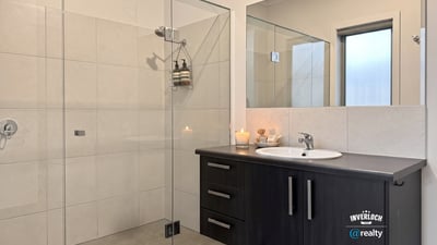 Modern bathroom featuring a spacious shower, sleek cabinetry, and natural light for a refreshing ambiance.