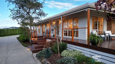 This inviting home features a spacious porch, landscaped gardens, and ample natural light throughout.