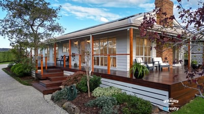 Inviting home features a spacious deck, landscaped garden, and picturesque setting, perfect for outdoor living.