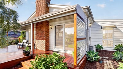 Inviting home features a spacious deck and lush landscaping, perfect for outdoor gatherings and relaxation.