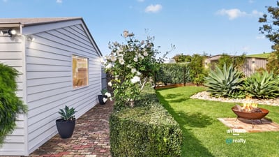 Discover a well-maintained outdoor space featuring lush greenery and a cozy fire pit for gatherings.