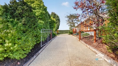 Discover this inviting pathway leading to a beautifully landscaped property, ideal for your future home.
