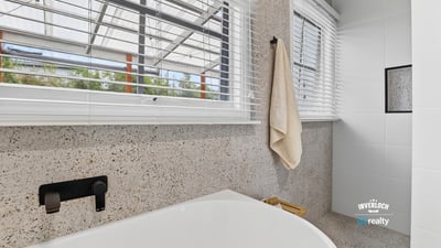 Bright and modern bathroom featuring a spacious tub and large windows for ample natural light.