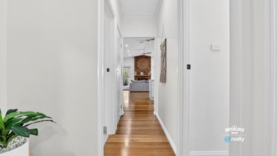 Bright, inviting hallway leading to a spacious living area, showcasing modern design and warmth throughout.