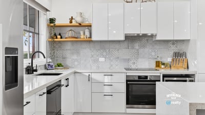 Modern kitchen featuring sleek cabinetry, advanced appliances, and eye-catching tile backsplash for a contemporary culinary experience.