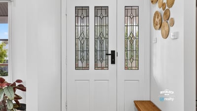 Inviting entryway featuring detailed glass doors and unique wall decor, perfect for welcoming guests.
