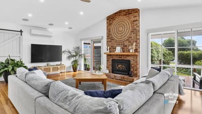 Spacious living area features a cozy fireplace, ample natural light, and direct access to outdoor views.
