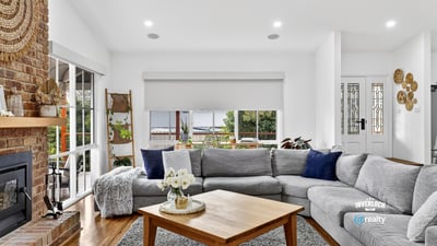 Spacious living area features large windows, offering abundant natural light and a cozy atmosphere.