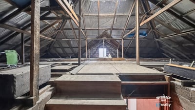 Spacious attic with exposed beams, offering limitless potential for customization or creative use.