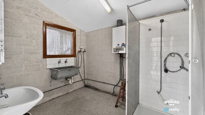 Spacious bathroom featuring a modern shower, practical sink area, and ample natural light.