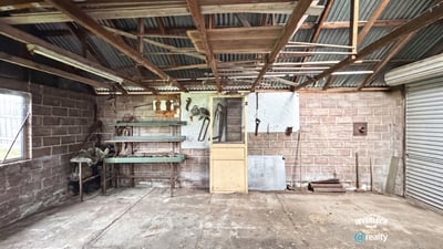 Spacious workshop with ample storage, ideal for projects or hobbies, featuring sturdy structures and natural light.