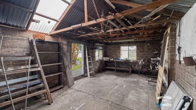 Spacious workshop with ample storage potential, featuring high ceilings and natural light for creative projects.