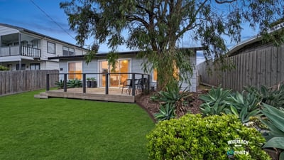 This cozy home features a welcoming deck and a spacious backyard, perfect for outdoor gatherings.