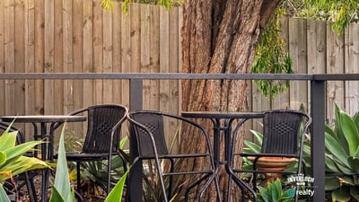 This inviting outdoor space features comfortable seating surrounded by lush greenery, perfect for relaxation or gatherings.