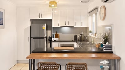 Bright kitchen featuring modern appliances, sleek cabinetry, and a cozy breakfast bar for casual dining.