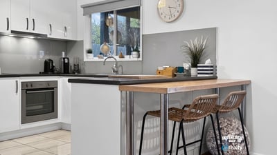 Modern kitchen featuring sleek cabinetry, a cozy breakfast bar, and ample natural light for culinary inspiration.