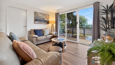 Bright and inviting living space featuring large windows, a cozy atmosphere, and easy outdoor access.