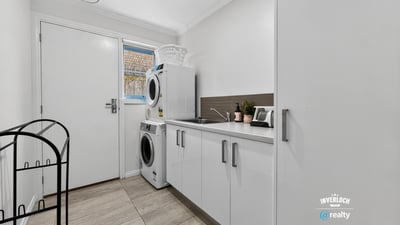 Bright and functional laundry area featuring modern appliances and practical storage solutions to enhance convenience.