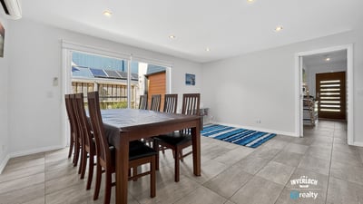 Spacious dining area with abundant natural light, featuring a versatile layout and easy access to outdoor spaces.
