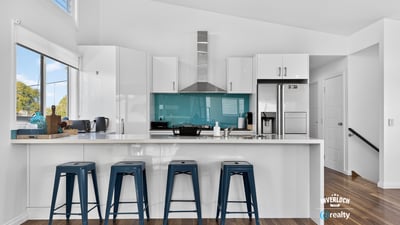 Modern kitchen featuring a striking turquoise backsplash, sleek cabinetry, and ample counter space for entertaining.