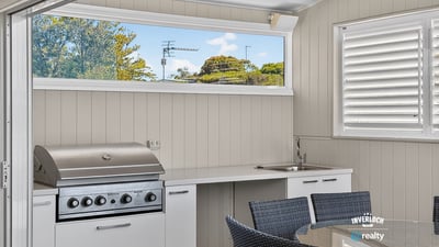This outdoor entertaining space features a built-in grill and modern kitchen perfect for gatherings.