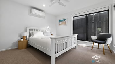 Bright and airy bedroom featuring large windows, modern furnishings, and a cozy atmosphere for relaxation.