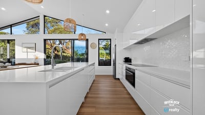 Modern kitchen featuring sleek cabinetry, ample natural light, and scenic views, perfect for culinary enthusiasts.