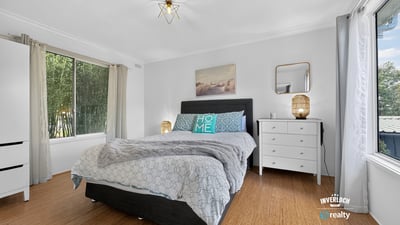 Spacious bedroom featuring abundant natural light, modern decor, and a cozy atmosphere for relaxation.