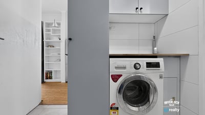 Compact laundry area featuring modern appliances and efficient storage solutions for optimal functionality.