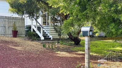 This property features a spacious yard with mature trees and a welcoming front porch, ideal for gatherings.