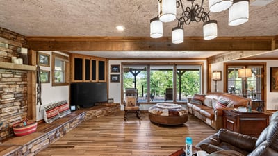 Spacious living area features a cozy layout with natural light, rich textures, and ample seating for gatherings.