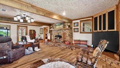 Discover a spacious living area featuring a unique stone fireplace and abundant natural light.