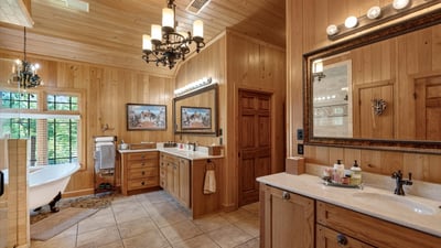 Spacious bathroom with natural wood accents, dual vanities, and a soaking tub for relaxation.