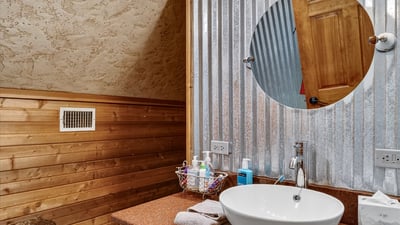 This unique bathroom features rustic wood accents and modern fixtures, creating a warm and inviting atmosphere.