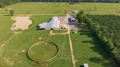 Sprawling rural property featuring vast pastures, a pond, and multiple outbuildings, ideal for farming or recreation.