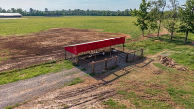 Versatile property featuring a spacious open field with a covered structure, perfect for agricultural or recreational use.