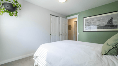 Bright bedroom featuring fresh paint, ample natural light, and a cozy atmosphere for relaxation.