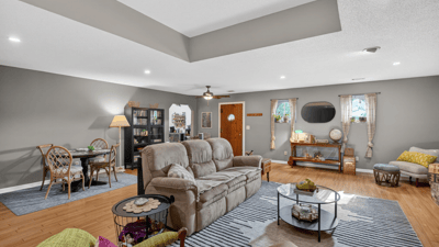 Spacious living area features modern decor, ample natural light, and versatile seating for relaxation or gatherings.