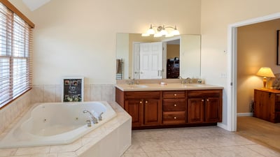 Luxurious Primary Bath with jetted tub, double vanity, and heated towel rack.